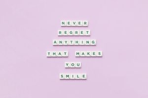 Inspirational quote using Scrabble tiles on a pastel pink background.
