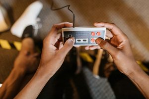 Close-up of hands holding a vintage game controller, capturing the essence of retro gaming.