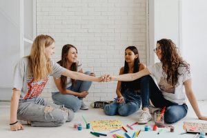 A group of teenage girls engaging in a creative art session, promoting teamwork and friendship.
