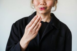 Close-up of a woman making a gesture with her hand against a white background. Ideal for communication themes.