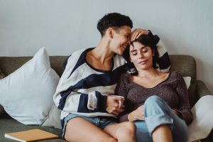 A couple enjoying a tender moment on a cozy couch, exuding warmth and affection.