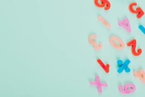 Vibrant plastic numbers arranged on a light teal backdrop with ample copy space.