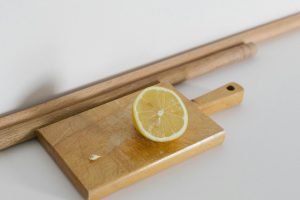 A fresh lemon slice on a wooden chopping board, perfect for culinary themes.