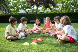 A group of kids enjoying outdoor games on a sunny day in a park in Portugal, fostering friendship and fun.