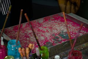 Colorful paint setup with brushes and creativity-filled bubbles in a tray.