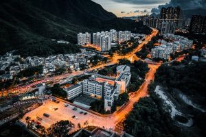 A captivating aerial view of an urban cityscape illuminated at dusk with glowing streetlights.