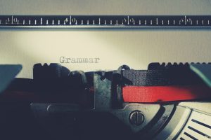 A detailed close-up of a vintage typewriter typing the word 'Grammar'.