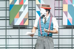 A clown with a pie-covered face on stage, showcasing comedic entertainment.