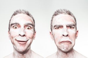 A whimsical portrait showing dual expressions of a man with a painted face.