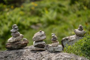 Stone cairns artfully balanced on rocks in a serene outdoor environment, symbolizing balance and harmony.