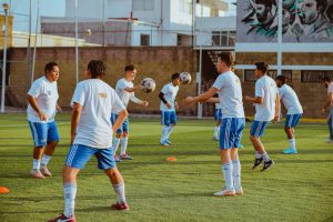 Group of young men practicing soccer on an outdoor field.