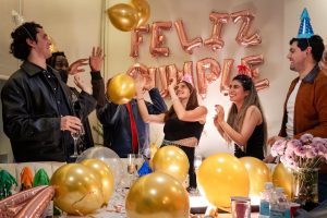 A vibrant birthday celebration with friends indoors, full of laughter and colorful decorations.