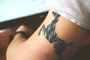 Detailed close-up of an abstract black arm tattoo on a person's skin, showcasing personal body art.