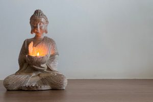 A calming Buddha statue with glowing candlelight, ideal for meditation settings.