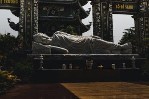 Serene reclining Buddha statue with ornate temple backdrop in Da Nang, creating a peaceful scene.