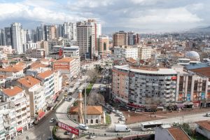 Aerial view of a bustling cityscape featuring modern high-rise buildings and busy streets.