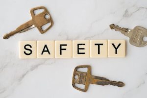 Close-up image of keys and scrabble tiles spelling 'safety' on a marble surface.