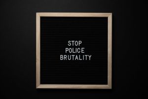 Overhead view wooden frame with white inscription about social injustice on black background