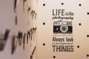Wall art with a photography-themed inspirational quote and vintage camera graphic.