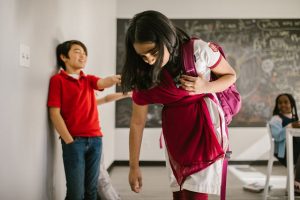 A group of children in a classroom, with a focus on bullying and its emotional impact.