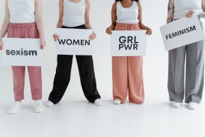Four women holding signs with messages of empowerment and feminism.