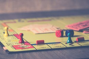 A close-up of a Monopoly board game with pieces and dice scattered around.