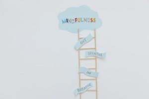 Creative mindfulness concept with ladder, words, and cloud shape for mental well-being.