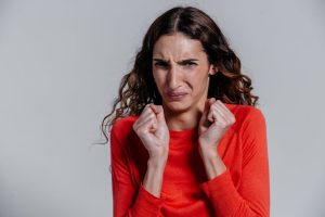 A woman displaying a disgusted facial expression indoors.