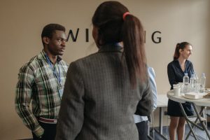 A diverse group of professionals networking at an indoor business seminar.