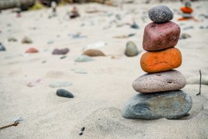 A close-up of stacked rocks on a sandy beach, emphasizing balance and harmony.