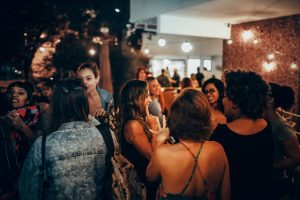 A vibrant group of adults socializing outdoors at night, creating a warm and lively atmosphere.